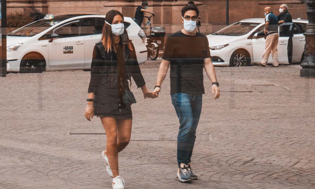 pareja con cubrebocas camina por las calles de Roma