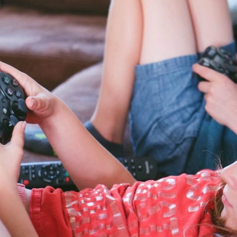 niños jugando videojuegos en casa educación