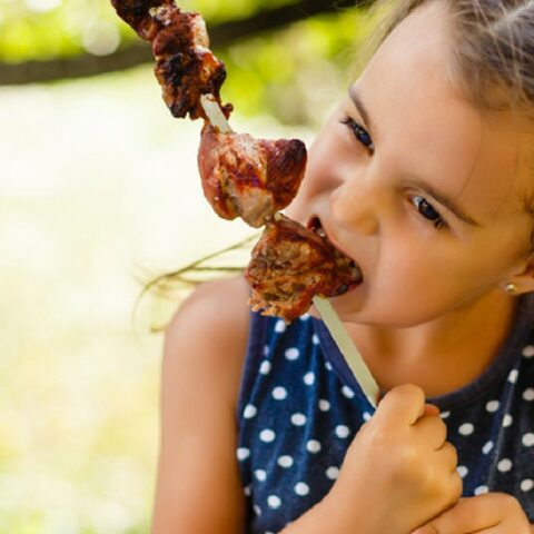 Niña vegana come carne