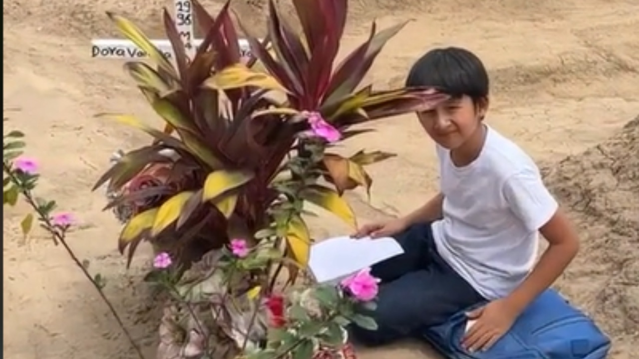niño hace la tarea en el panteón